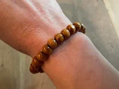 Vorschau: Holzperlen-Armband „Jahresringe“ am Handgelenk – honigbraune Holzperlen mit gestreifter Maserung