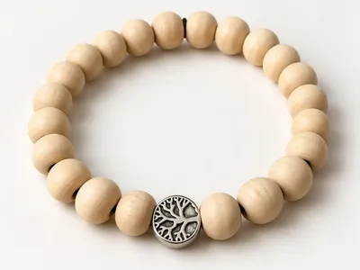 Vorschau: Armband „Yggdrasil“ – naturhelle Holzperlen mit silberfarbener Lebensbaum-Perle auf weißem Grund
