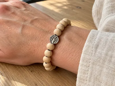 Vorschau: Armband „Yggdrasil“ mit Lebensbaum am Handgelenk, getragen auf einem Holztisch