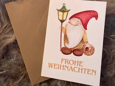 Vorschau: Klappkarte „Wichtel mit Laterne“ mit Kraftpapier-Umschlag auf einem hellen Fell