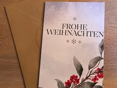 Vorschau: Klappkarte „Winterbeeren“ mit Umschlag aus Kraftpapier auf einem Holztisch